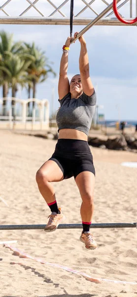 Bardan sarkan güçlü bir bayan sporcu, Barselona 'daki Santa Susanna plajındaki Sparta Yarışı engelli parkurunda....