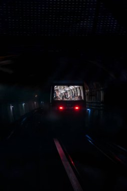 Karanlık bir tünele giren Paris metrosunun arka görüntüsü,