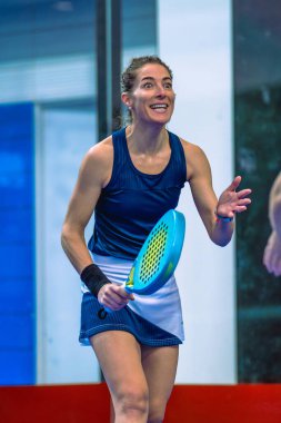 Kapalı alanda oynanan harika bir maçtan sonra mutlu bayan padel oyuncusu heyecanlı bir yüz ifadesi sergiliyor..