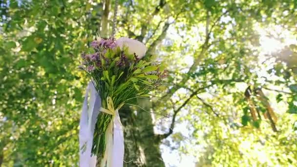 Ленты свадебного букета, привязанные к качелям под деревом — стоковое видео