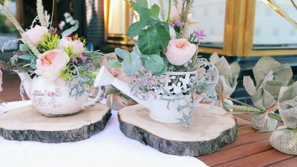 Decoração de casamento de bule de porcelana e uma pequena lata de rega decorada com arranjos florais — Vídeo de Stock