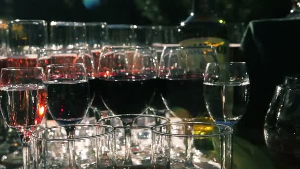 Molti Colpi di Vodka e Bicchieri di Vino Spumante stanno su una Tavola da Servire — Video Stock