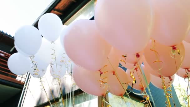 Muchos globos blancos y rosados festivos con helio — Vídeo de stock