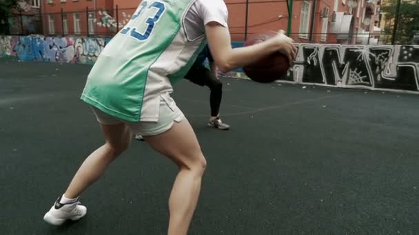 Jonge Man en vrouw in de straat basketbal spelen — Stockvideo