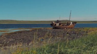 Rusya 'nın Rybachy Yarımadası' ndaki Barents Denizi kıyısında terk edilmiş bir gemi. Yumuşak kamera hareketi.