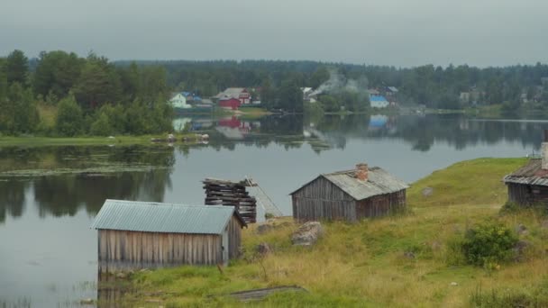 Starý vratký dřevěný dům ve vodě na břehu jezera v ruské Karelii. V pohybu. — Stock video