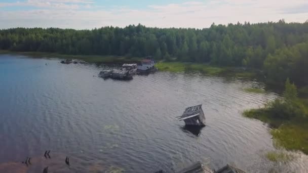 Vista aérea de la orilla del lago en Karelia con casas inclinadas hundidas en el agua, Rusia. — Vídeo de stock