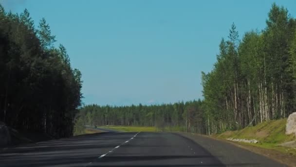 Панорамный вид на дорогу из окна движущегося автомобиля. Кольское шоссе через Карелию, Россия. — стоковое видео