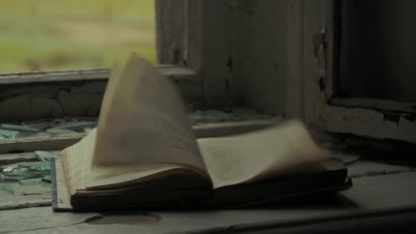 Οι σελίδες ενός βιβλίου φτερουγίζει σε ένα σπασμένο περβάζι σε ένα εγκαταλελειμμένο σχολείο στο χωριό Teriberka, Ρωσία. — Αρχείο Βίντεο
