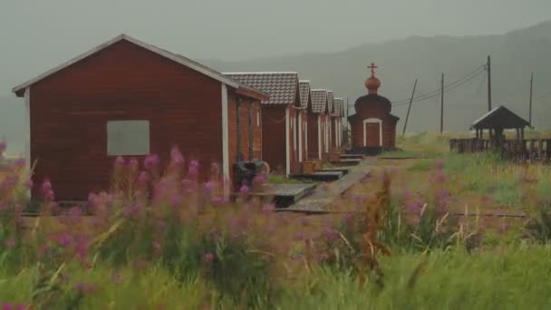 Новые дома и церковь в далекой северной деревне Териберка, Россия. — стоковое видео
