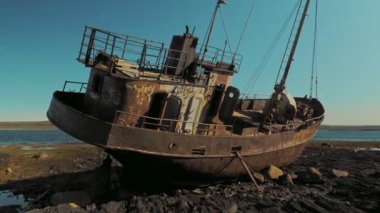 Rusya 'nın Rybachy Yarımadası' ndaki Barents Denizi kıyısında terk edilmiş bir gemi. Yumuşak kamera hareketi.