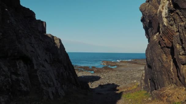Výhled na poloostrov Rybachy, Rusko. Otvor skal je bránou času na břehu mysu Cemerski. Hladký pohyb fotoaparátu. — Stock video
