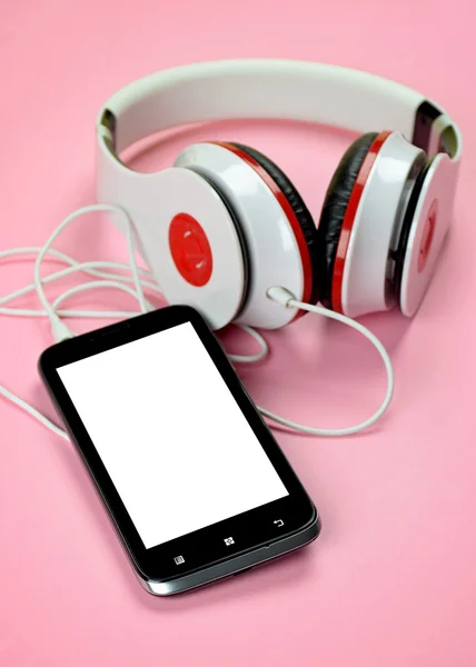 Headfones e smartphone em fundo rosa . — Fotografia de Stock