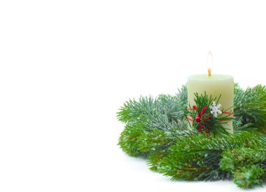 Ladin dallarında yanan bir mum. Noel çelengi. Toprakla kaplanmış bir ağaç. Noel mumu. Uzayı kopyala. Beyazda izole edilmiş.