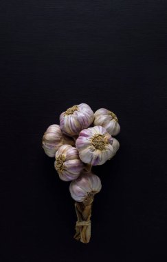 Sarımsak. Koyu ahşap kaplamalı sarımsak soğanları. Taze, mor bir sarımsak ampulünün yakın plan görüntüsü. Sarımsak soğanı ve sarımsaklı karanfil. Mesaj için yer var. Düz yatıyordu. Şablon.