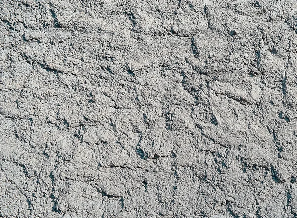 plaster wall with grain and cracks. Cracked wall closeup photo. Architecture detail background. Empty concrete wall. Grungy surface of painted cement. Abstract grainy texture