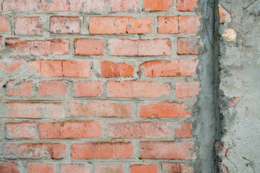 Tuğladan yapılmış el yapımı tuğla duvar. Soyut arka plan dokusu. Eski, kirli ve eski tarz. Duvarda gri macunlu kırmızı tuğla var. Tuğla ekran koruyucu. Boş tuğla duvar.