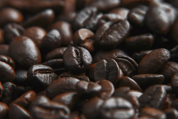 Roasted coffee beans on a stone background. Coffee beans texture. Coffee in beans on dark background. Food background of coffee beans. Abstract background .Coffee beans texture.