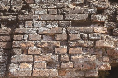 Kırmızı tuğla, harabelerin bir parçası ve yıkılmış ortaçağ binaları, yakın çekim. Antika tuğla işi. Kale duvarı. Kaliteli duvar yapısı. eski yıkılmış tuğla duvar.