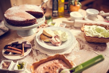 A lot of desserts on the kitchen table.Celebration,holiday sweet food.Birthday feast.Catering food,service.Cafeteria,restaurant kitchen