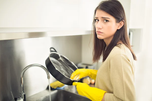 Handreinigung.junge Hausfrau spült Geschirr in der Küche. Müde vom Putzen, macht ein trauriges Gesicht — Stockfoto