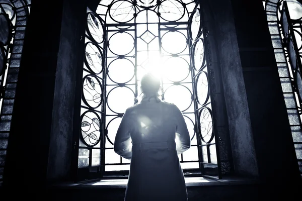 Mujer cristiana religiosa mirando a través de la luz de la ventana de la iglesia vidrieras. Mujer rezando a Dios en la catedral de San Alejandro Nevski. Encontrar la serenidad en la religión, la fe y el concepto de esperanza . — Foto de Stock