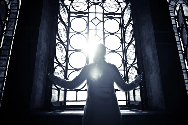 Encontrar la serenidad en la religión, la fe y la esperanza concept.Enlightenment.Religious mujer cristiana mirando a través de la luz vidriera ventana de la iglesia — Foto de Stock