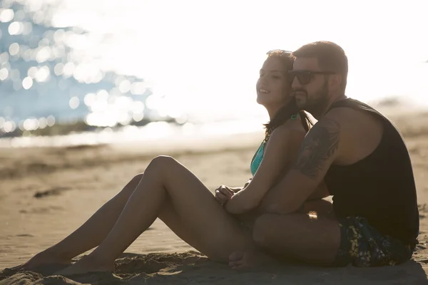 Romantisches Paar in Umarmung beobachten Sonnenaufgang / Sonnenuntergang zusammen. junger Mann und Frau in Liebe umarmen und genießen Tag am Strand. Flirten im Sommerurlaub. Horizont beobachten, winken.romantik — Stockfoto