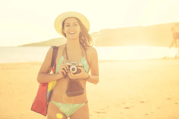 Attractive fit trendy modern hipster woman taking photos with retro vintage film camera.Lifestyle photographer.Summer beach woman taking picture during summer holiday