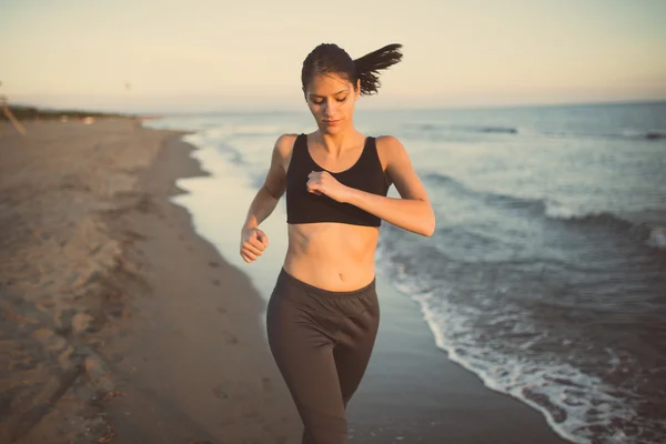 Mujer corredora corriendo en la playa en sujetador deportivo top.Beautiful ajuste mujer fitness entrenamiento de la mujer y hacer ejercicio al aire libre en verano como parte de un estilo de vida saludable —  Fotos de Stock