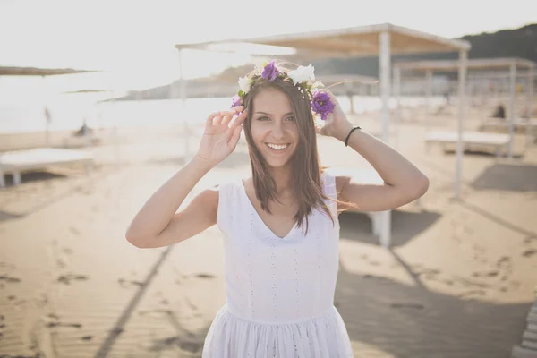 Summer beach fashion woman enjoying summer and sun, walking the beach near clear blue sea, smiling at camera