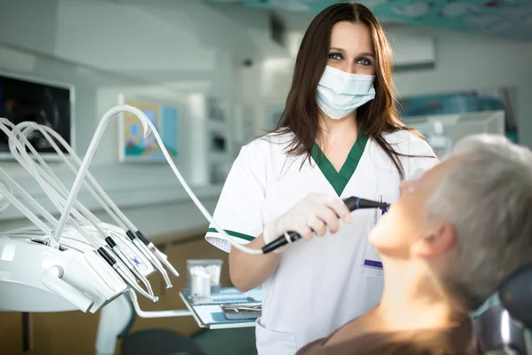 Oude vrouw met een bezoek aan de tandarts het verzorgen van haar tanden... Tandheelkundige zorg voor oudere. Prosthodontics en orale protesis — Stockfoto