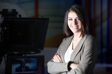 Kameranın yanında stüdyo durduğunu, genç güzel esmer televizyon spiker. TV yönetmeni Studio düzenleyici