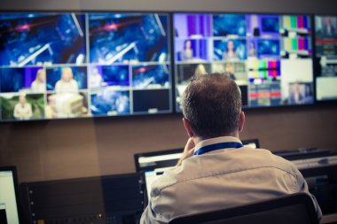 Studio düzenleyici, TV yönetmeni. Tv yönetmeni vizyon karıştırıcı bir televizyon yayın galeride konuşuyor. Paneli karıştırma bir vizyon oturdu adam