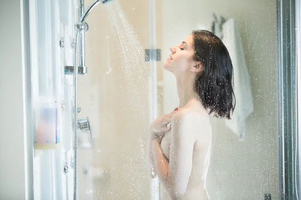 美しいブルネットの女性は 長いストレスの多い一日の後シャワーを浴びて 女性シャワーとモダンなデザインのバスルームでお風呂を楽しんでいます 肌ケアのコンセプト — ストック写真