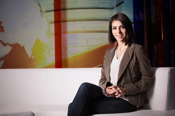 Jeune belle brunette présentatrice de télévision au studio debout à côté de la camera.TV réalisateur à l'éditeur en studio — Photo