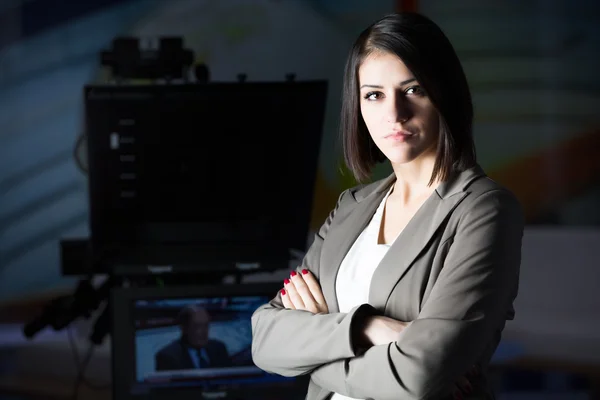 Giovane bella bruna annunciatore televisivo in studio accanto alla camera.TV direttore al redattore in studio — Foto Stock