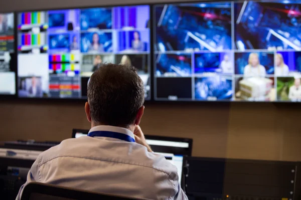 Studio düzenleyici, TV yönetmeni. Tv yönetmeni vizyon karıştırıcı bir televizyon yayın galeride konuşuyor. Paneli karıştırma bir vizyon oturdu adam