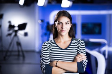 Young beautiful brunette television announcer at studio standing next to the camera.TV director at editor in studio.Recording at TV studio with television anchorwoman. TV NEWS studio behind the scenes clipart