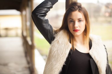 Gorgeous brunette standing on the train station portrait. Fashion portrait of young beauty woman outdoors