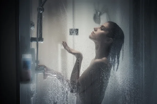 Relief and relaxation after long stressful day.Taking moment for yourself concept.Skincare,spa and aromatherapy.Unfocused portrait of a woman showering through the bath screen with little drops — 스톡 사진