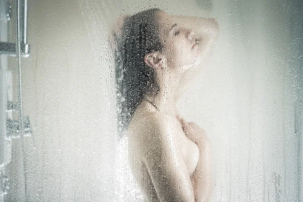 Relief and relaxation after long stressful day.Taking moment for yourself concept.Skincare,spa and aromatherapy.Unfocused portrait of a woman showering through the bath screen with little drops — 스톡 사진