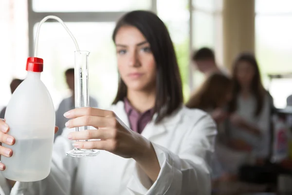 Chercheur scientifique tenant une eau déionisée purifiée distillée dans des bouteilles en plastique avec une pompe. Mesure cylindre gradué pour mesurer le volume d'eau.. Eau pour solutions chimiques — Photo