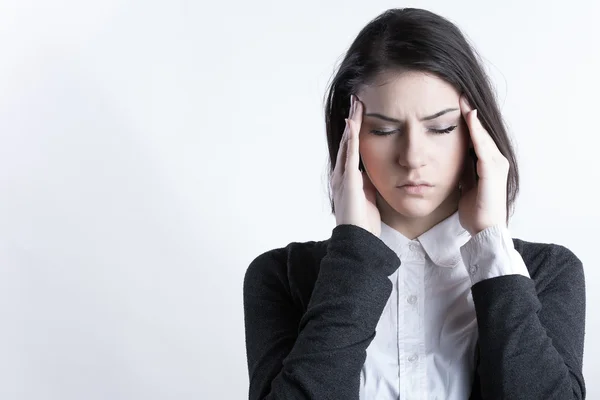 Young woman holding her head.Migraine and headache problem.Overworked,stressed woman.Menstrual and period pain.Intensive lifestyle and fast life. — Stock Photo, Image