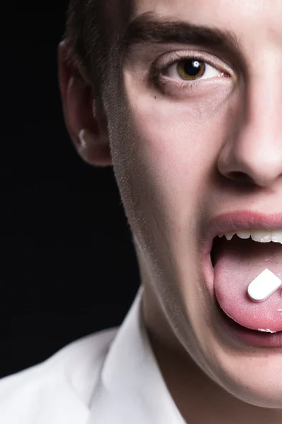 Drugs abuse and addiction tablets.Drug abuse,health danger.Young man under drug influence.Adolescent taking drugs for fun.Young man abusing prescription drugs,painkillers.Party.Ecstasy.Mean evil face — Stock Photo, Image