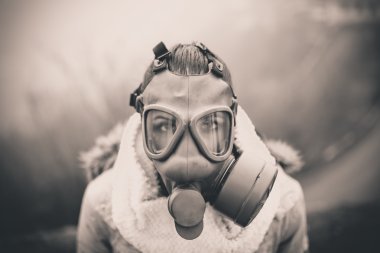 Environmental disaster.Woman breathing trough gas mask,health in danger.Concept of pollution,apocalypse.Polluted air,environmental problems.Riot with gas mask.Smog,poisonous particles,bio hazard