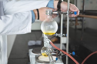 Bilimsel araştırmacı bir kimyasal deneme araştırma yapıyor. Bilim öğrencileri kimyasallar ile çalışma. Kimyager laboratuar ekipmanları ile araştırma yapıyor. Eczacı damıtma işlemi gerçekleştirme