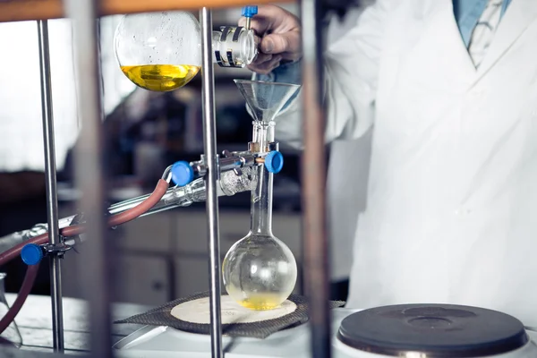 Scientific researcher doing a chemical experiment research.Science students working with chemicals. Chemist doing research with laboratory equipment. Pharmacist performing distillation process — Stock Photo, Image