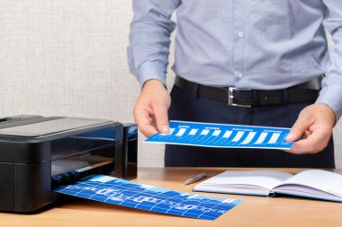 İşadamı evrakları ofiste basıyor. İnsan iş yerindeki pazar tablosunu analiz eder. 