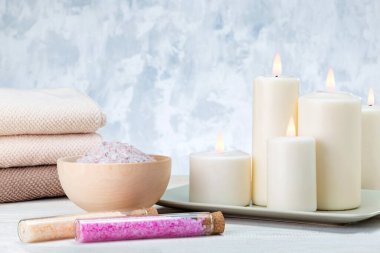 Deniz tuzu, banyo havlusu ve yanan mumlarla kaplıca kompozisyonu.